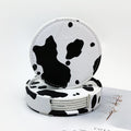 Classic cow print leather coaster, round design with white background and black spots
