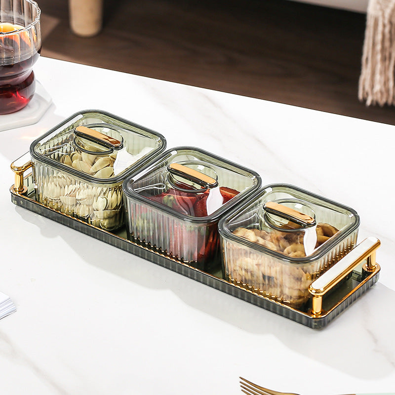Set of glass containers with gold handles on a white surface