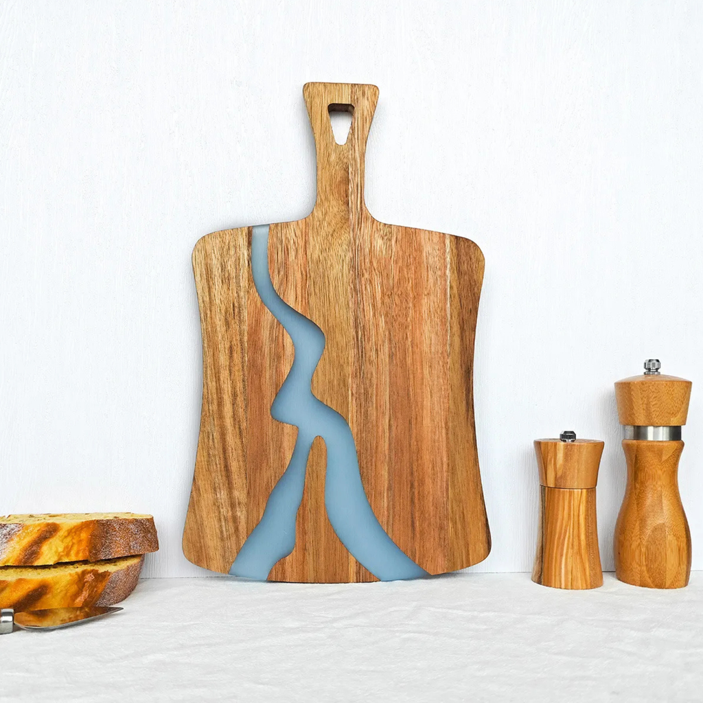 Acacia wood serving board featuring blue epoxy resin river and top carrying slot