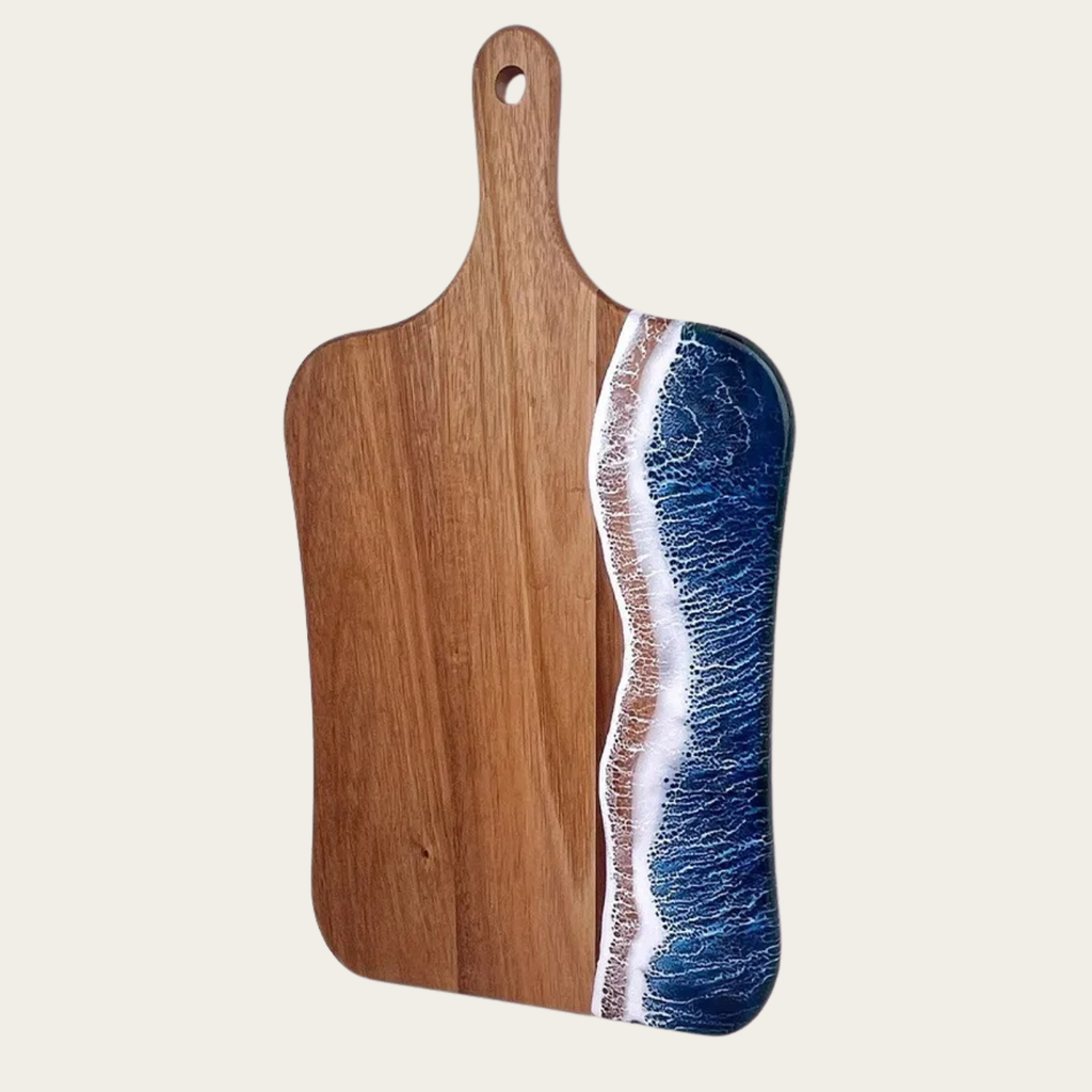 Wooden cutting board with a blue resin design on a beige background