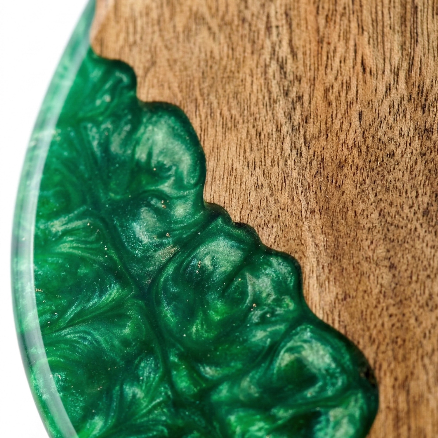 Close-up of green resin inlay on pine nut shaped acacia wood cutting board