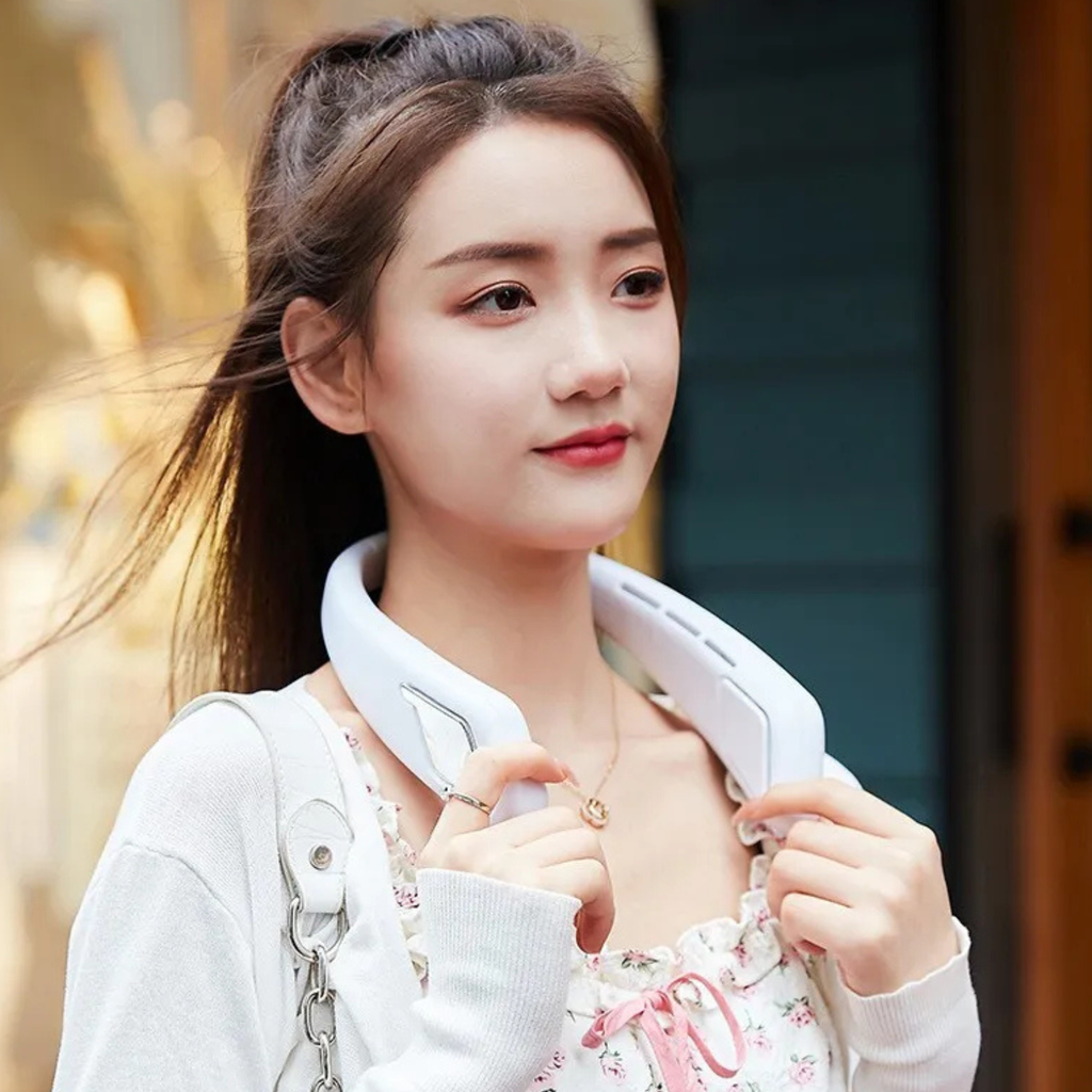 Woman wearing a white bladeless neck fan around her neck