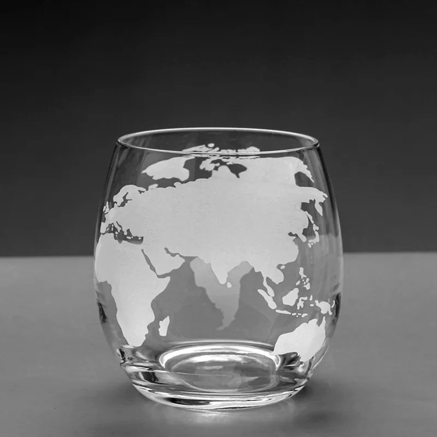 Clear glass with world map etching on a dark background
