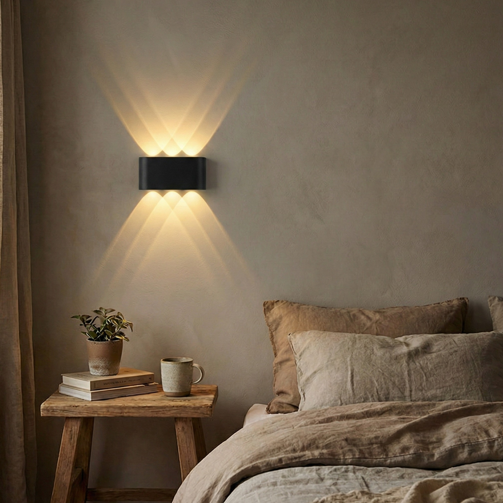 Up-down LED wall sconce beside bed, warm white light, black housing