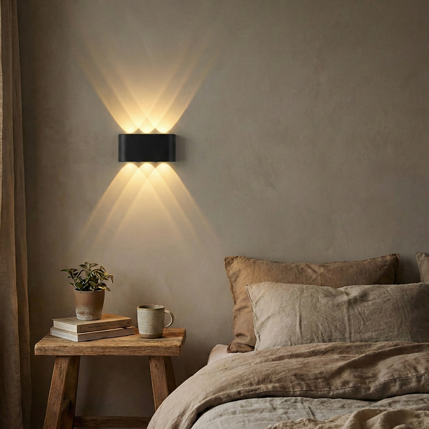 Up-down LED wall sconce beside bed, warm white light, black housing