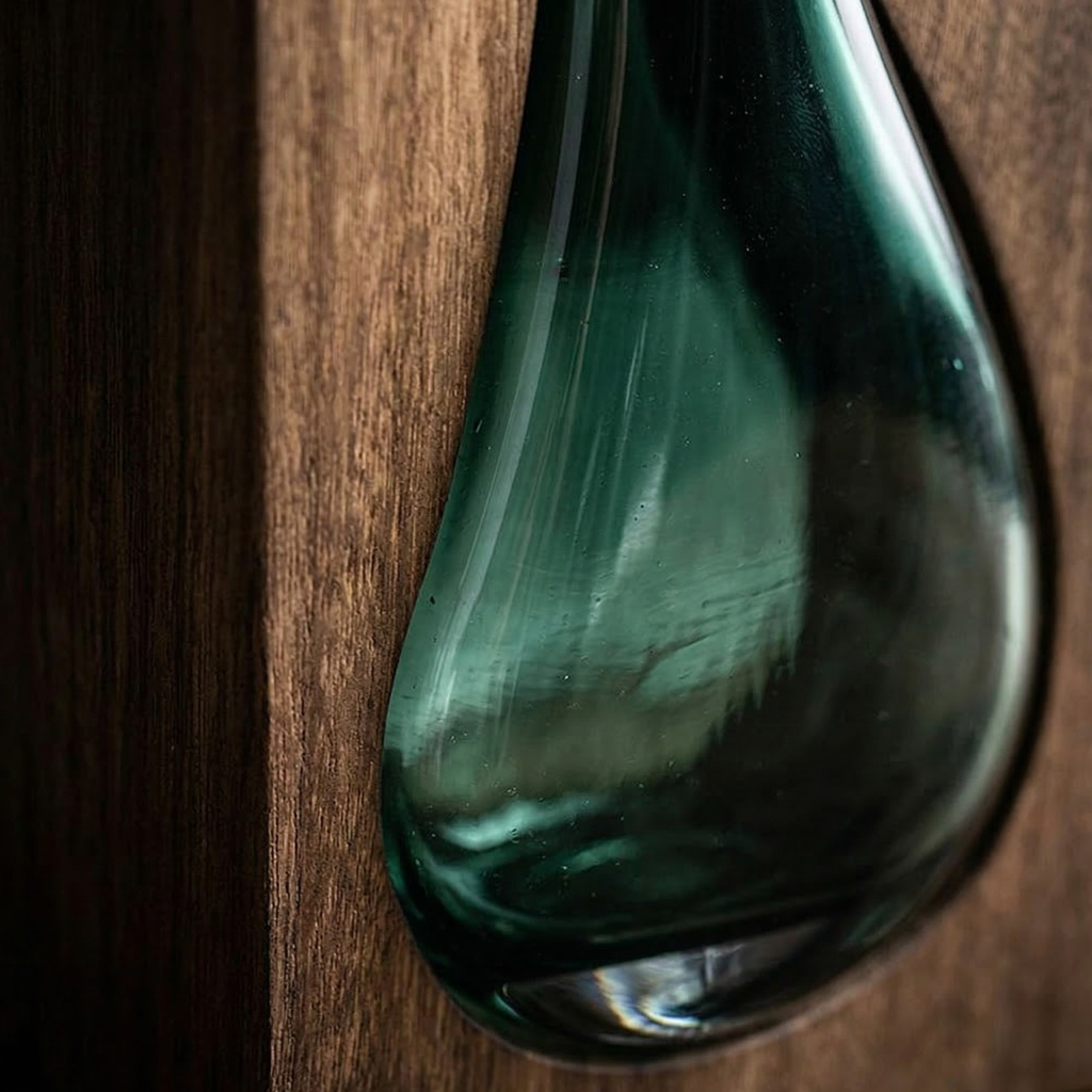Close-up of green glass vase and wood base texture