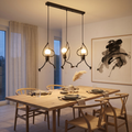 Dining room with wooden table, chairs, and pendant lights.