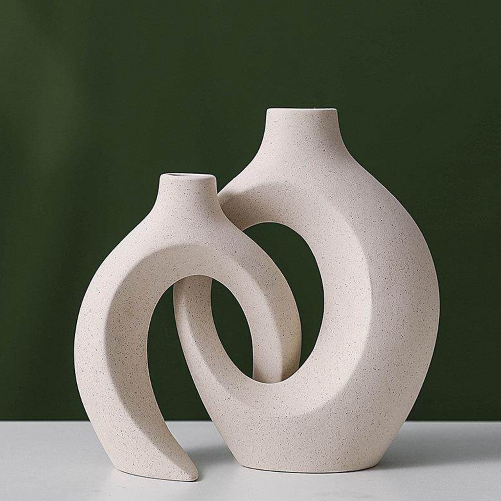 Pair of hollow resin vases in pearl color with oval cutout interlock