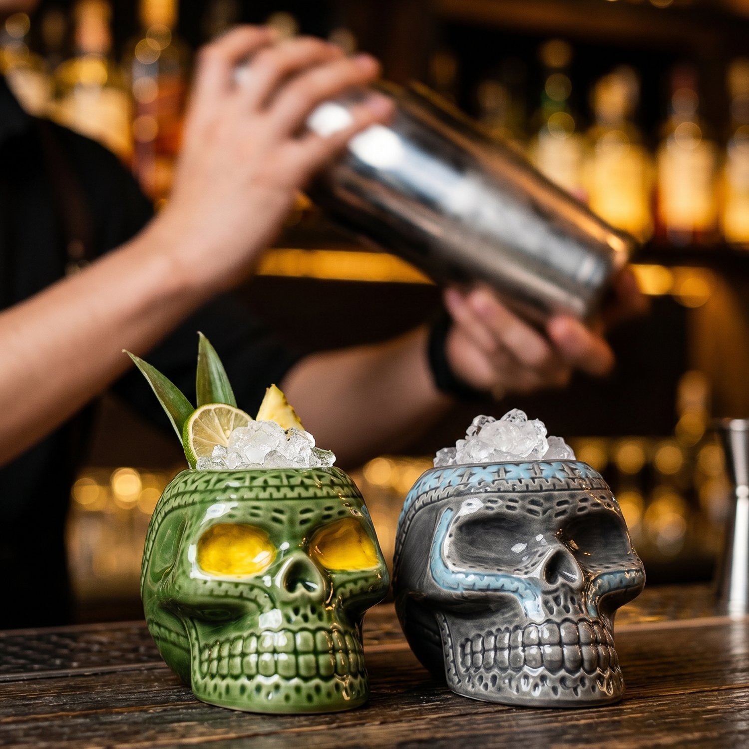 Green ceramic pirate skull tiki mug with ice, lemon wedge and mint leaf