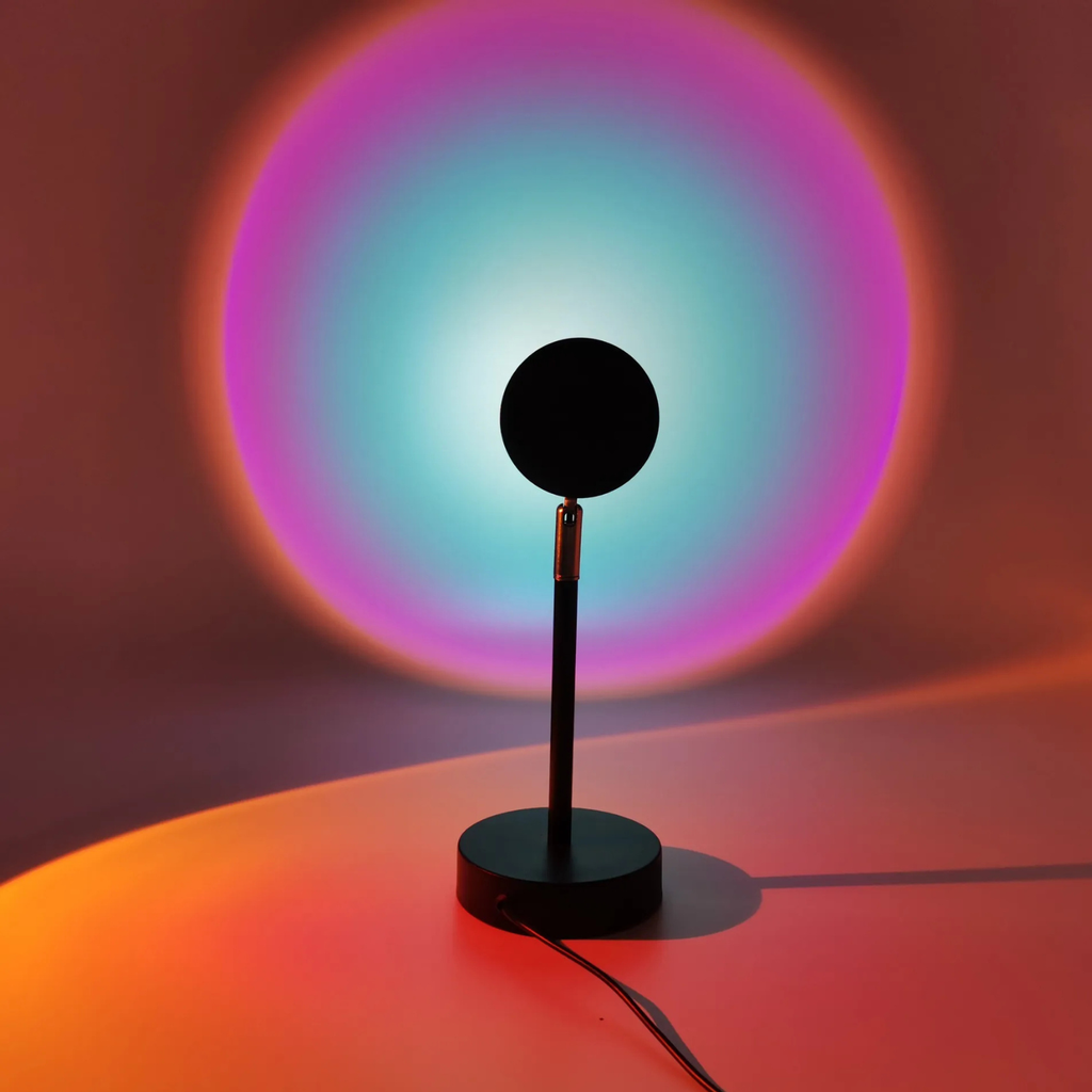Black lamp with a colorful circular light projection on a dark background
