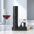 Black wine opener set with a glass of red wine on a marble surface.