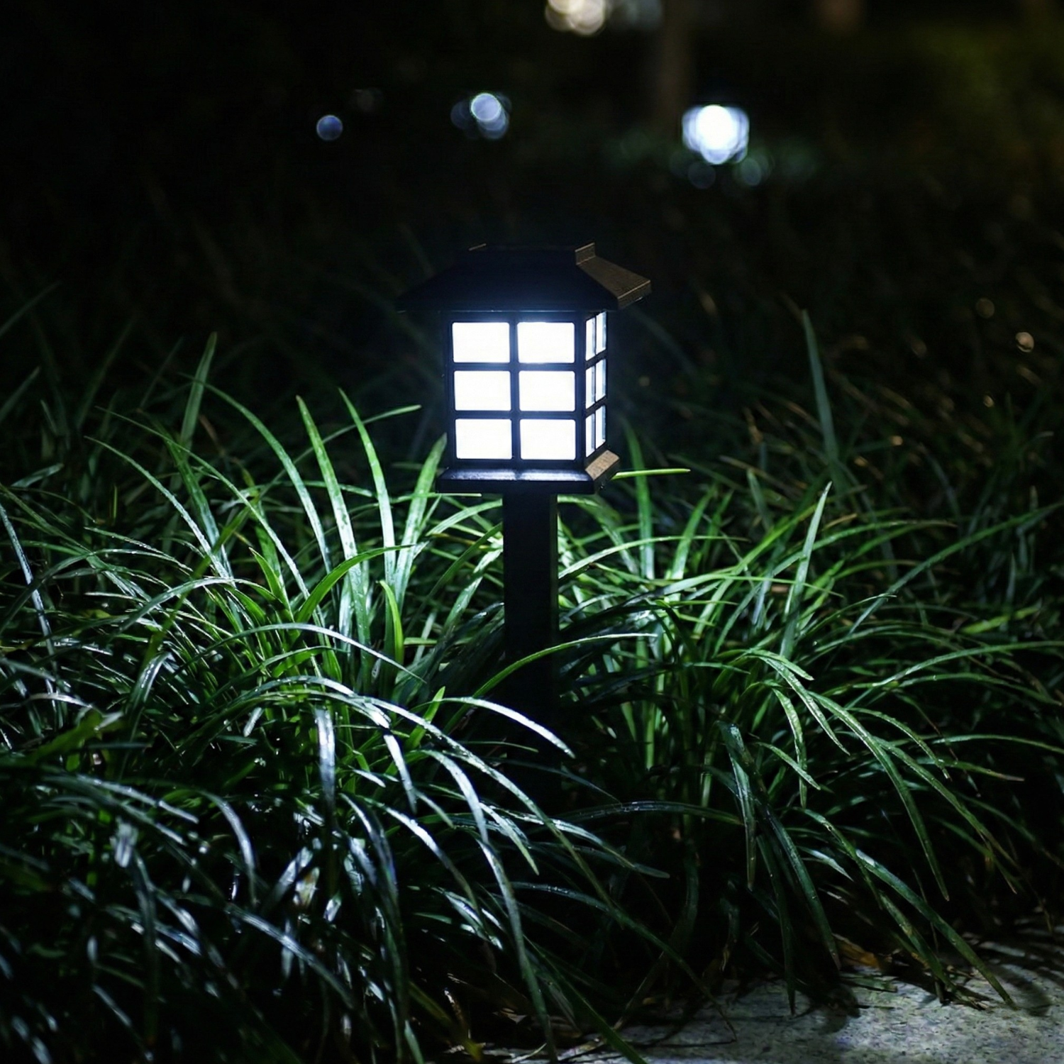 Solar path light with cool white lantern glow and black stake in grassy yard