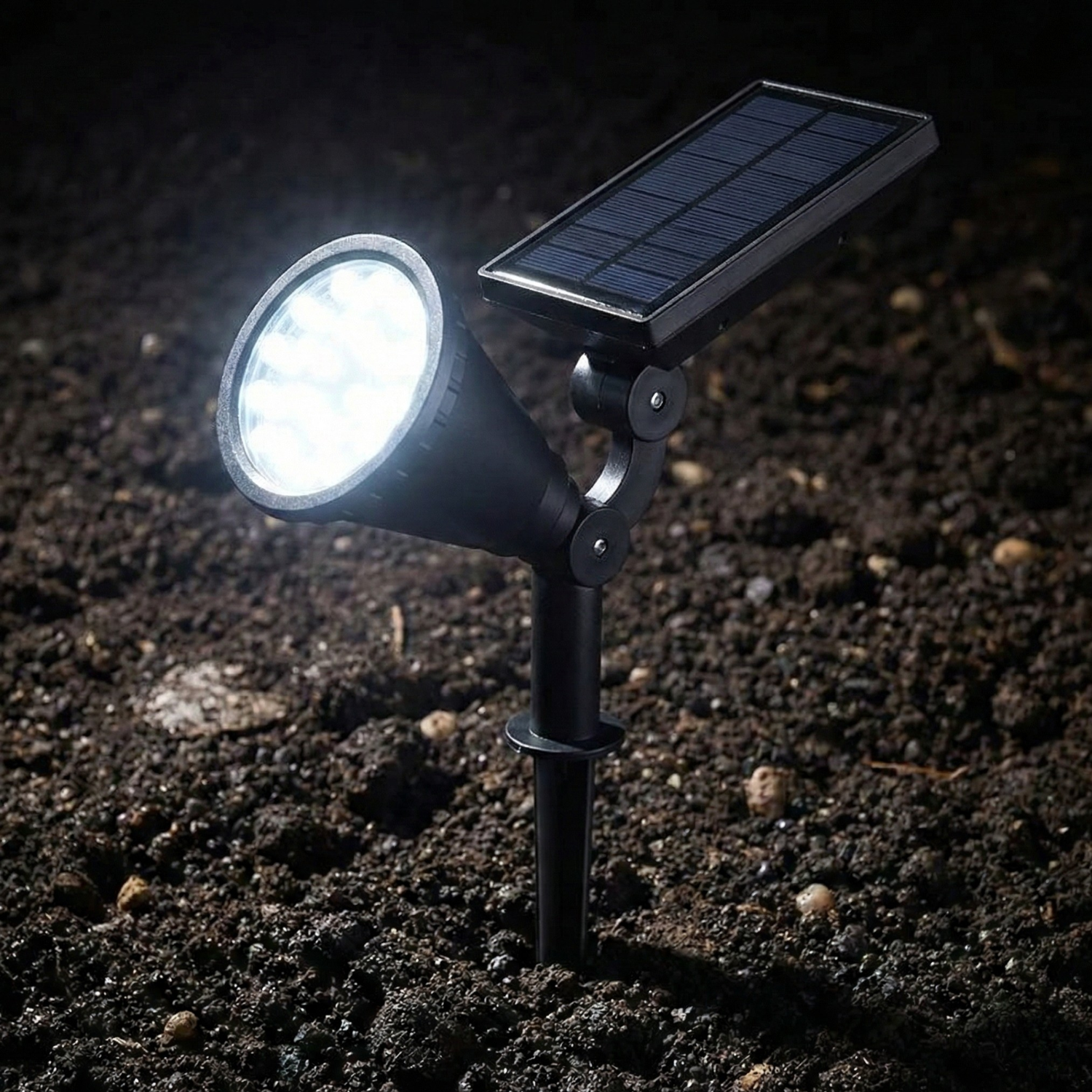 Black solar stake light with round lens, cool white bright glow over soil