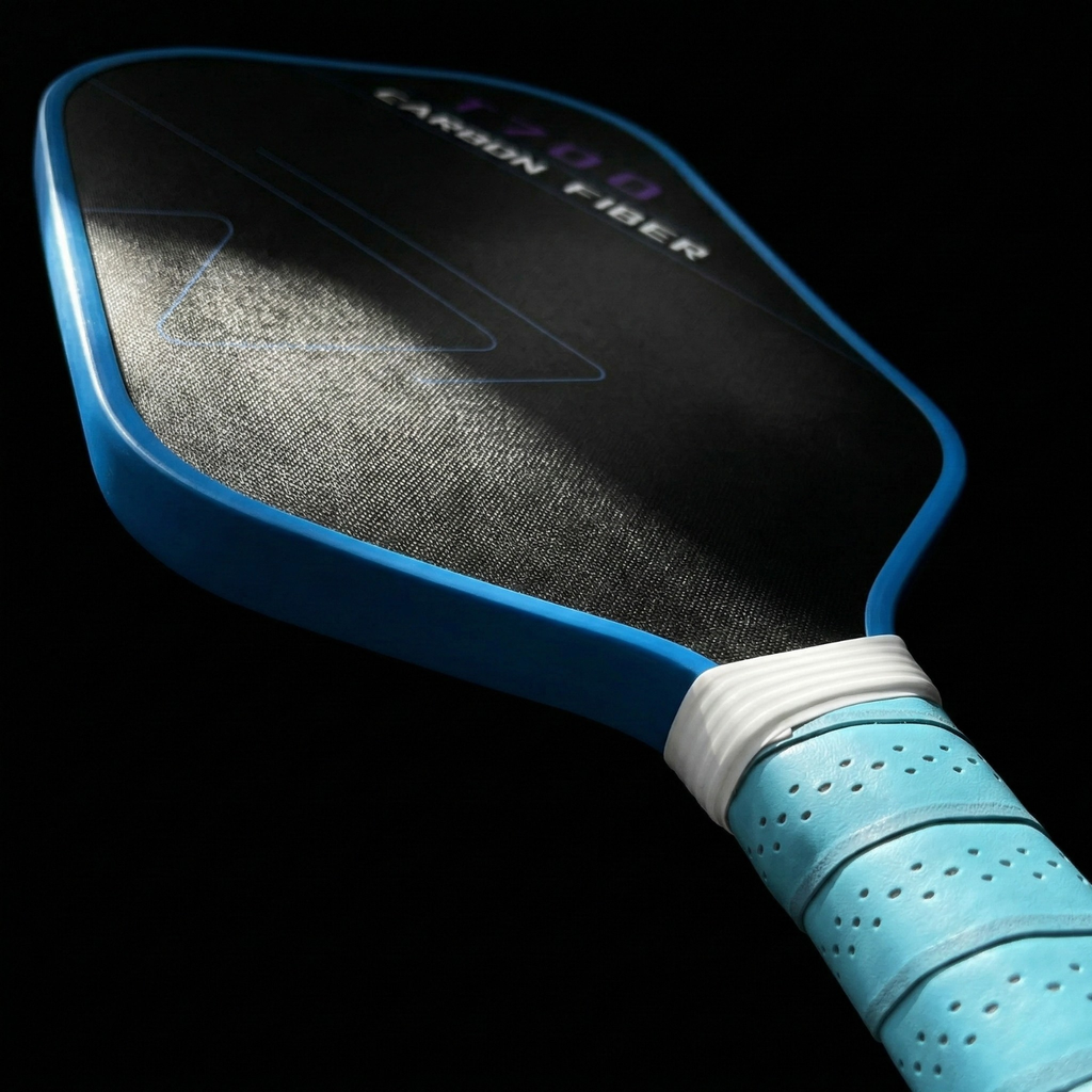 T700 carbon-fiber pickleball paddle close-up: black textured face and turquoise grip