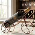 Antique bronze tricycle wine bottle holder with black bottle and gold cap