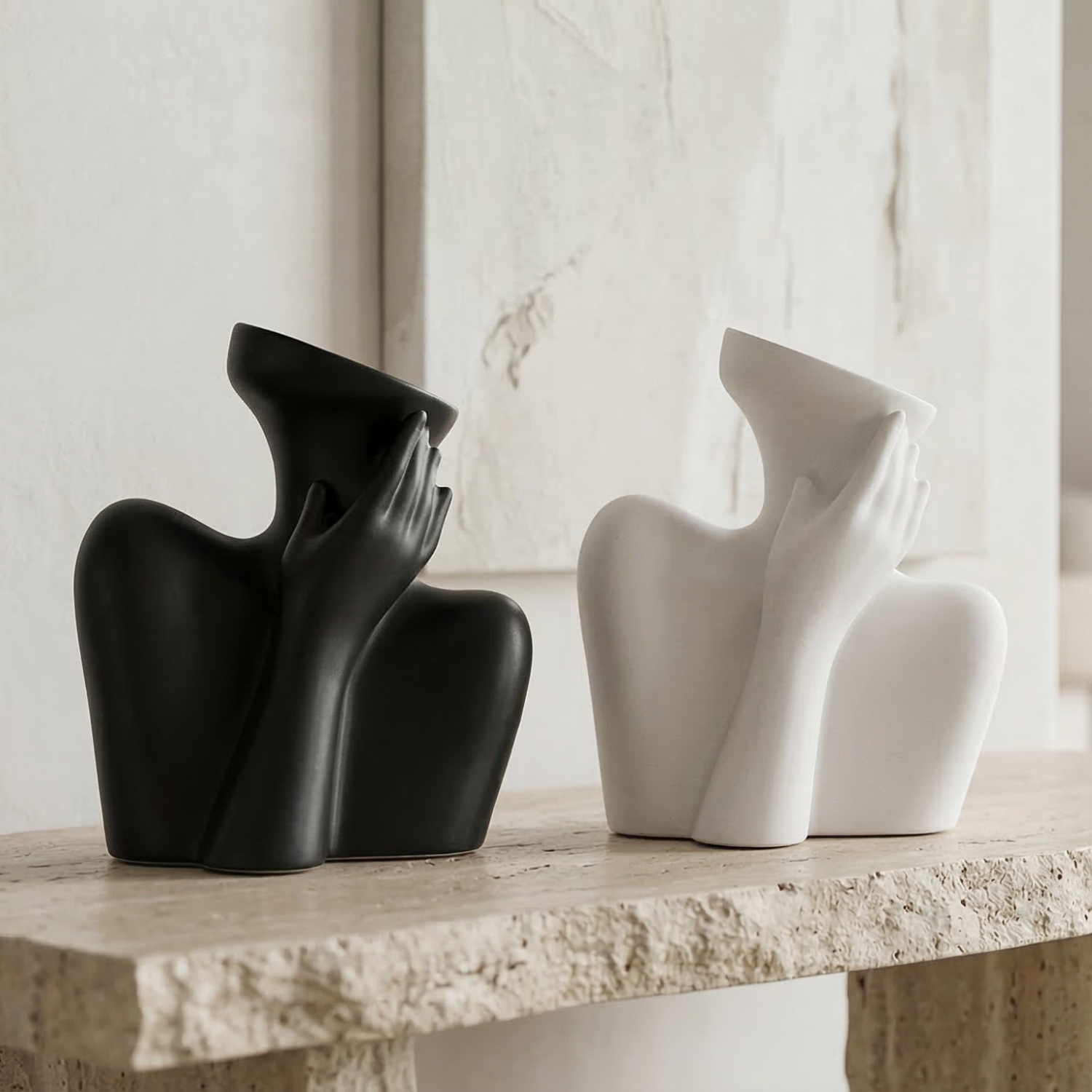 Black and white ceramic human-form vases, each with hand-on-face cheek design