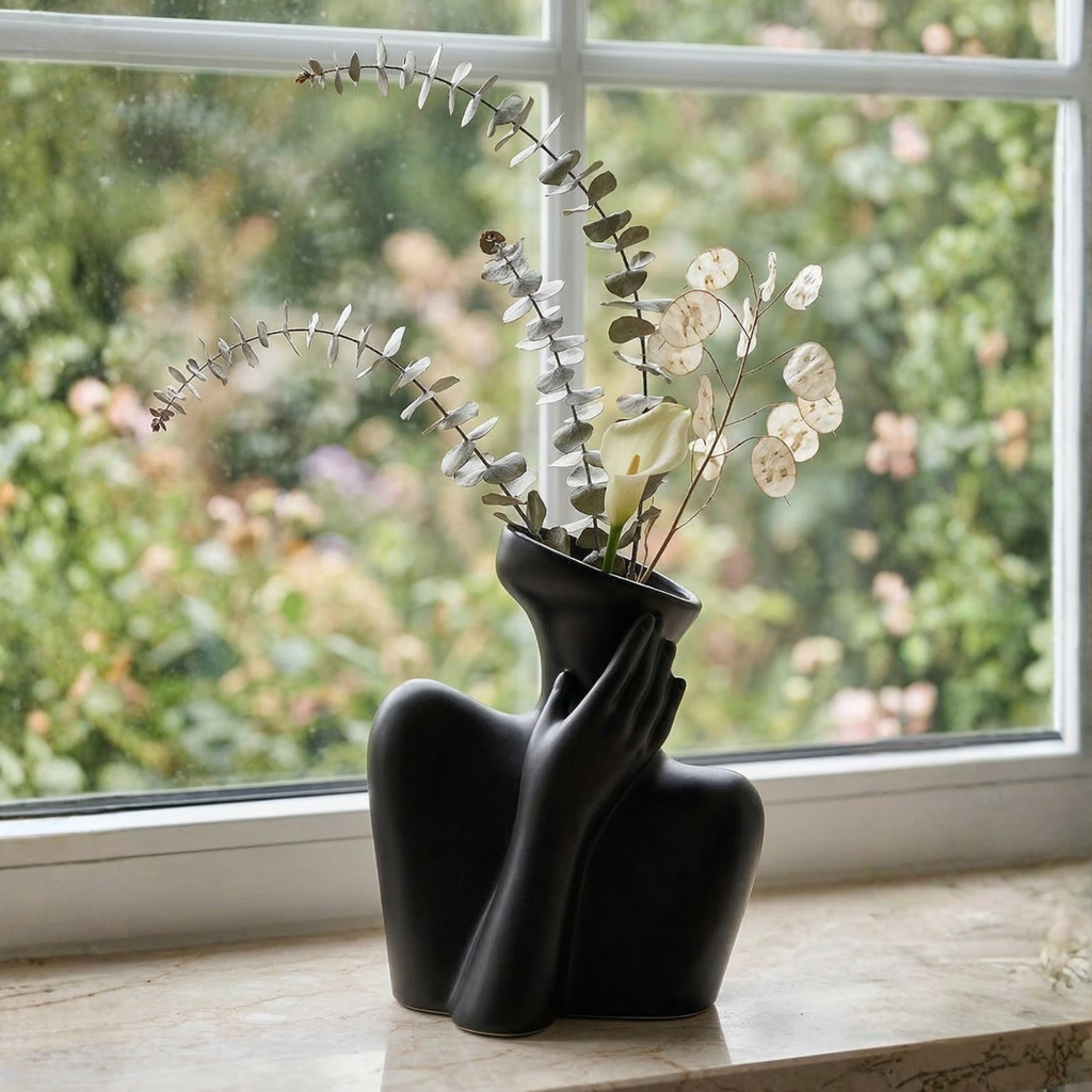 Black sculptural ceramic human vase with hand-on-face pose and wide bowl opening