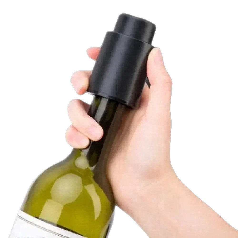 Hand holding a black vacuum wine stopper to seal a wine bottle
