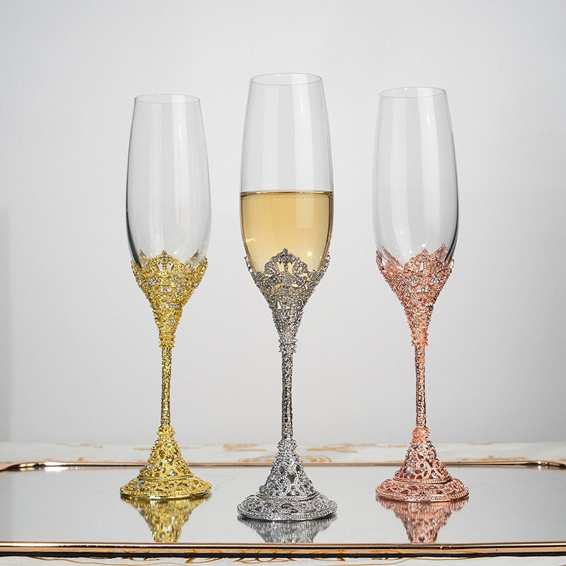 Three ornate champagne flutes with gold, silver, and rose gold bases on a reflective surface.