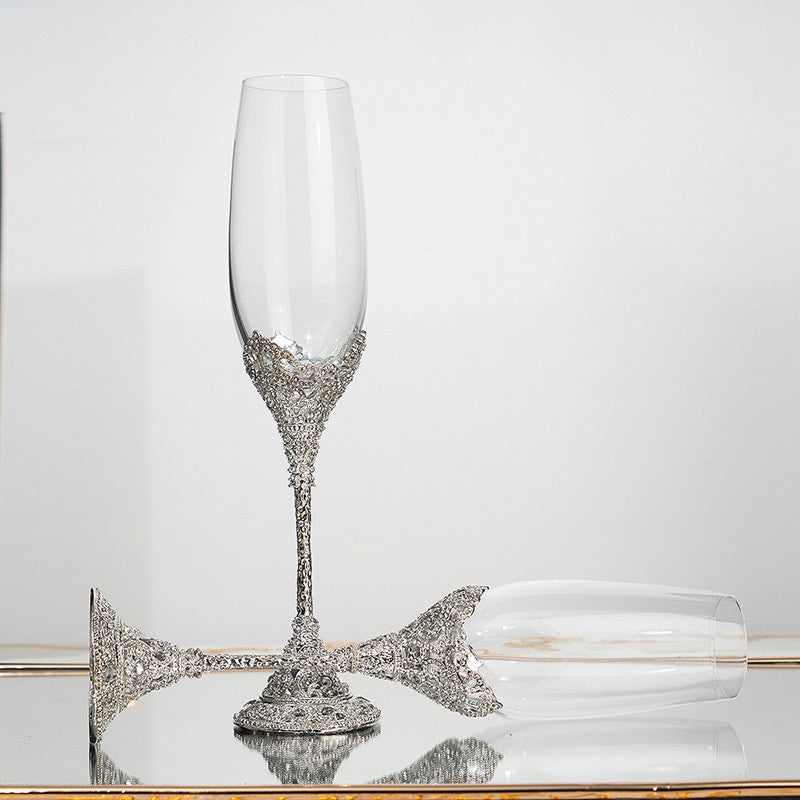 Decorative champagne flute with silver embellishments on a reflective surface.
